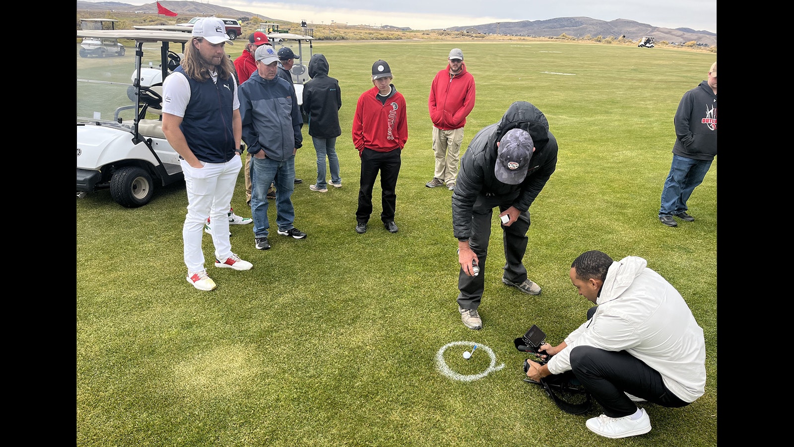Official landing spot of record long drive carefully marked as Kyle Berkshire looks on, left, along with members of the Rawlins High School golf team.
