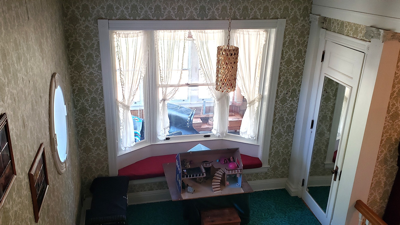 A dollhouse placed near a window at the J.B. Okie Mansion.