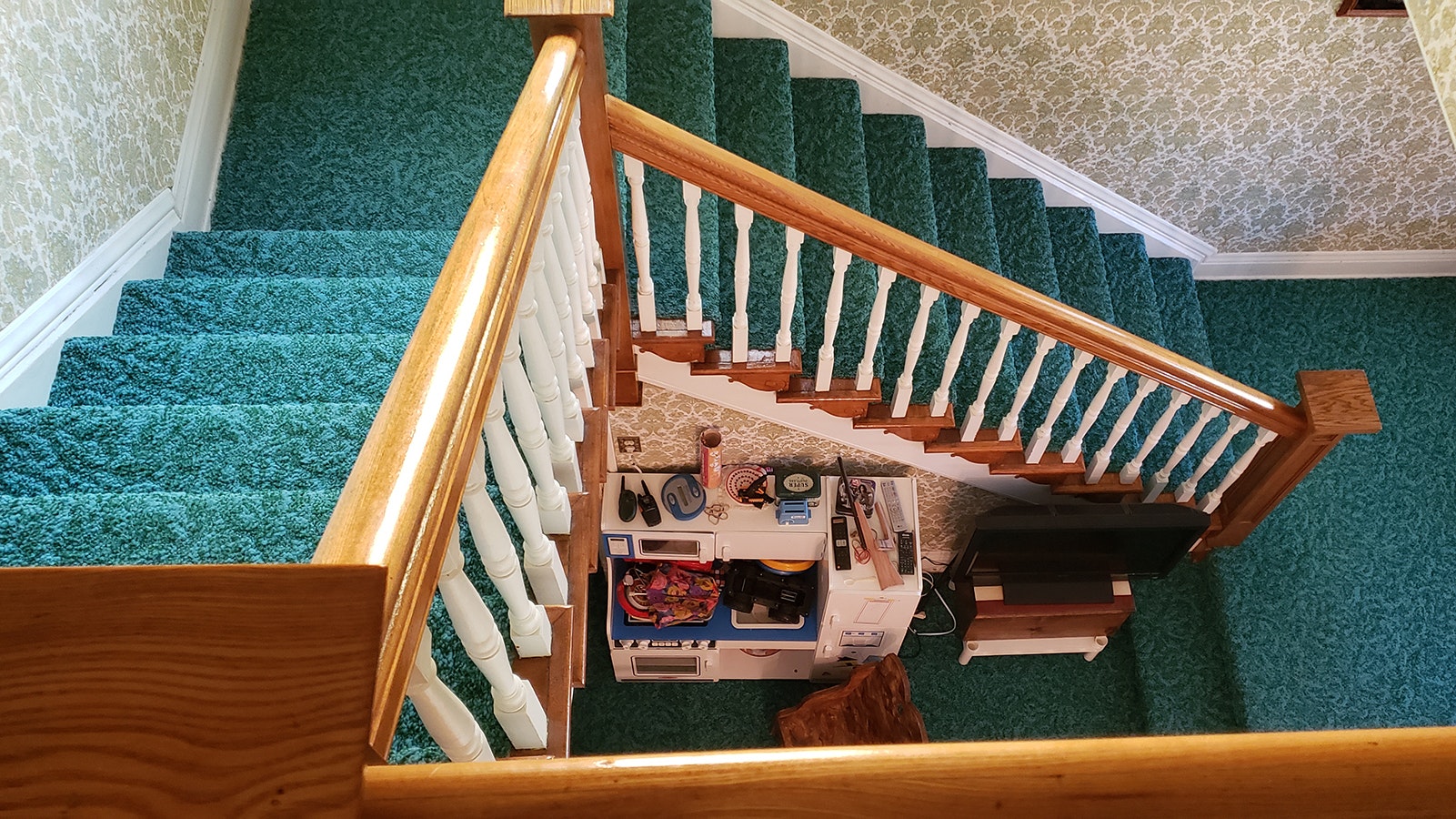 One of two stairwells leading downstairs .A child's play area has been placed in the cubby at the bottom.