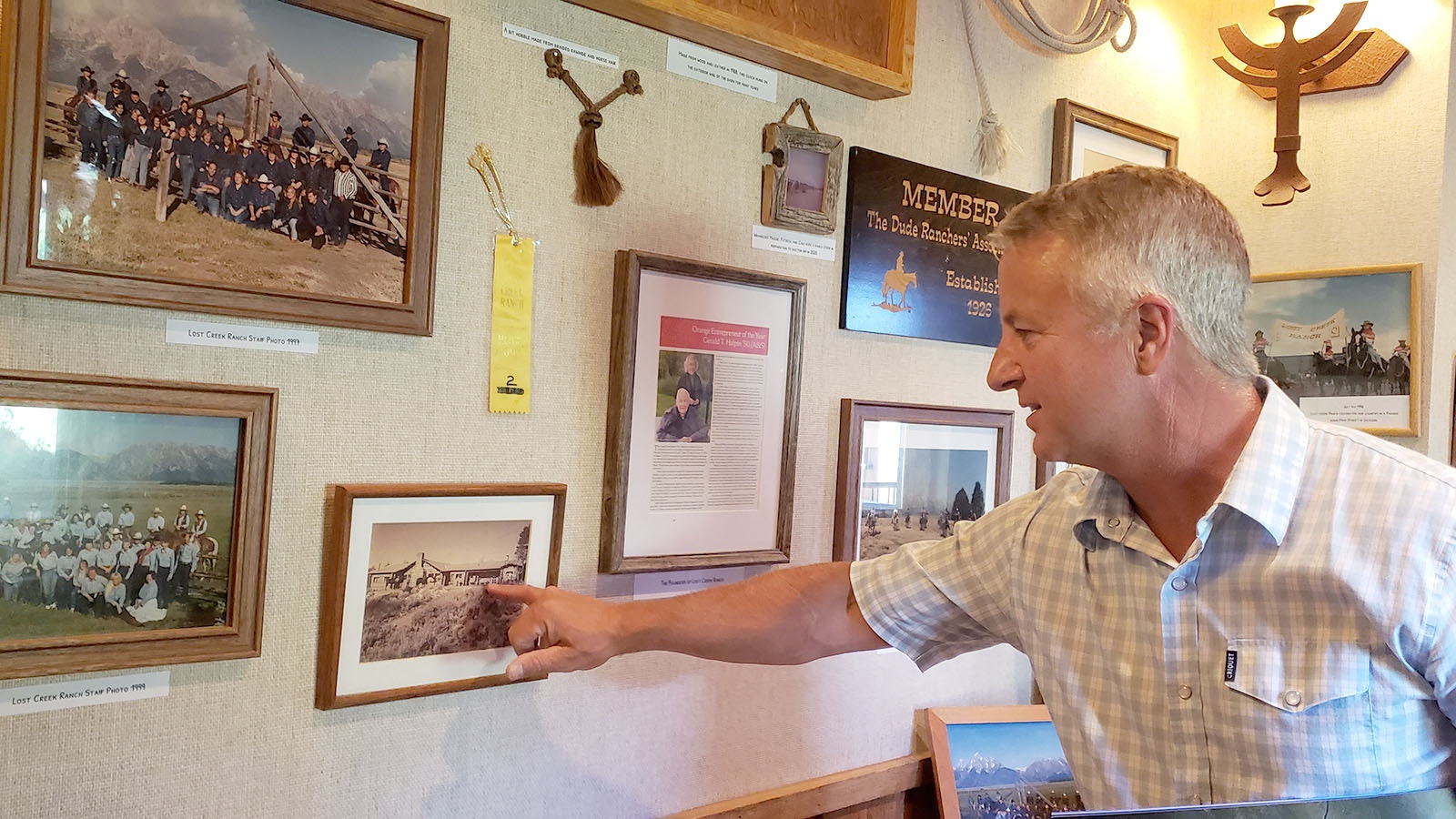 Latham Jenkins points at an old photo of the Lodge at Lost Creek.