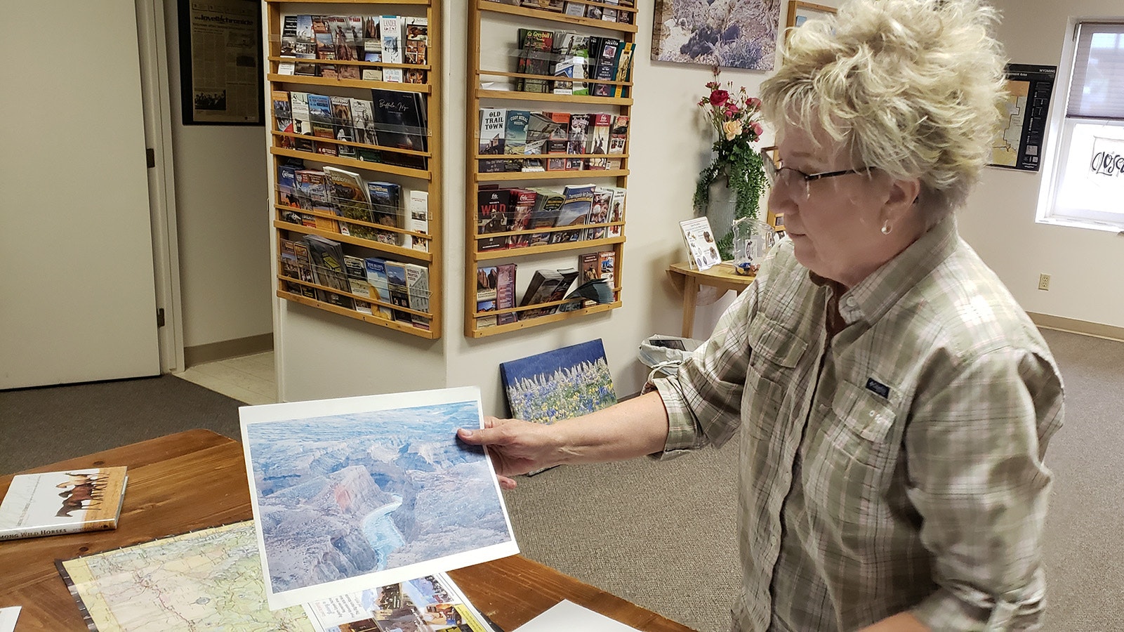 Linda Morrison holds up a photo of the Bighorn Recreation Area and Pryor Mountains.