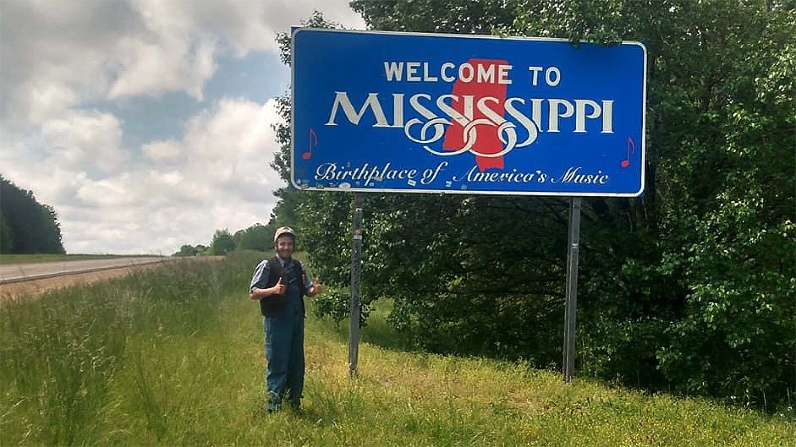 Luke Bell poses underneath the border sign leading into Mississippi.