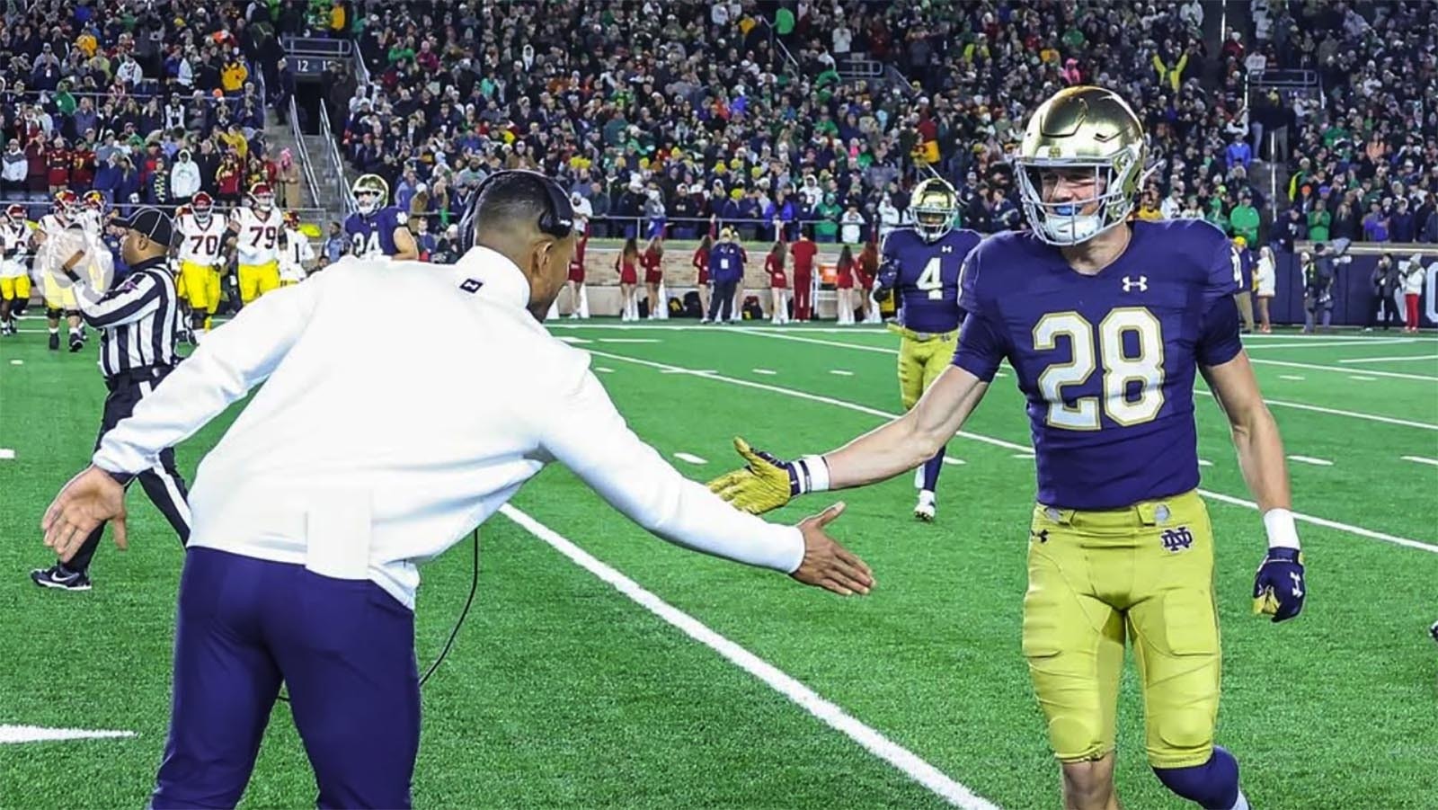 Notre Dame football coach Marcus Freeman greets Luke Talich as he comes off the field.