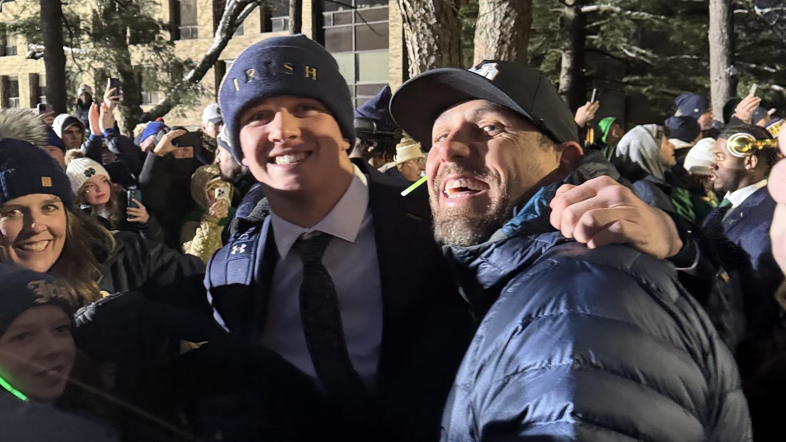 Luke Talich, left, and his Cody High School football coach Matt McFadden greet each other during the Victory Walk from mass to the stadium on Friday night at Notre Dame University.