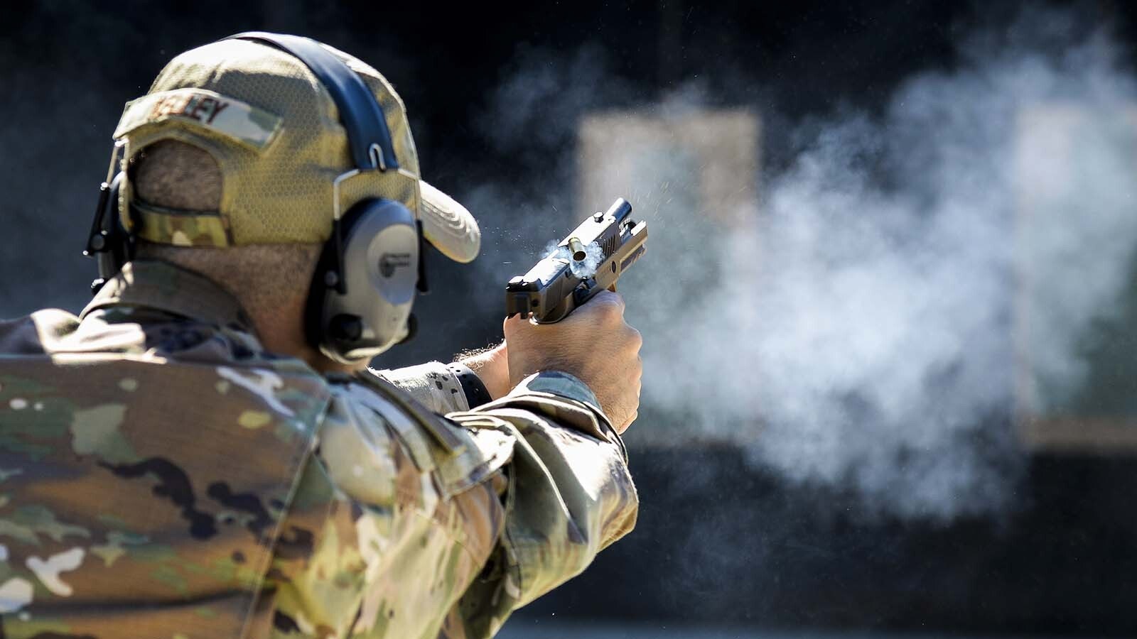 An airman in the U.S. Air National Guard fires a Sig Sauer M18 handgun in this file photo. The section of the U.S. Air Force that oversees the military branch’s bases is putting the Sig Sauer M18 handgun back in use, the USAF announced Sunday. It had paused the M18’s use for a month after the July shooting death of a Wyoming-based airman.