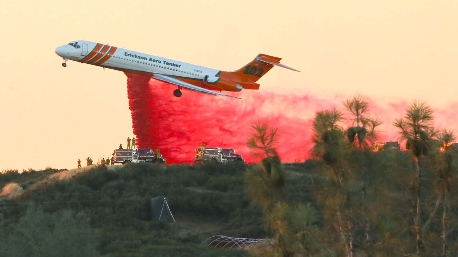 An MD-87 air tanker drops a load of slurry on a wildfire.