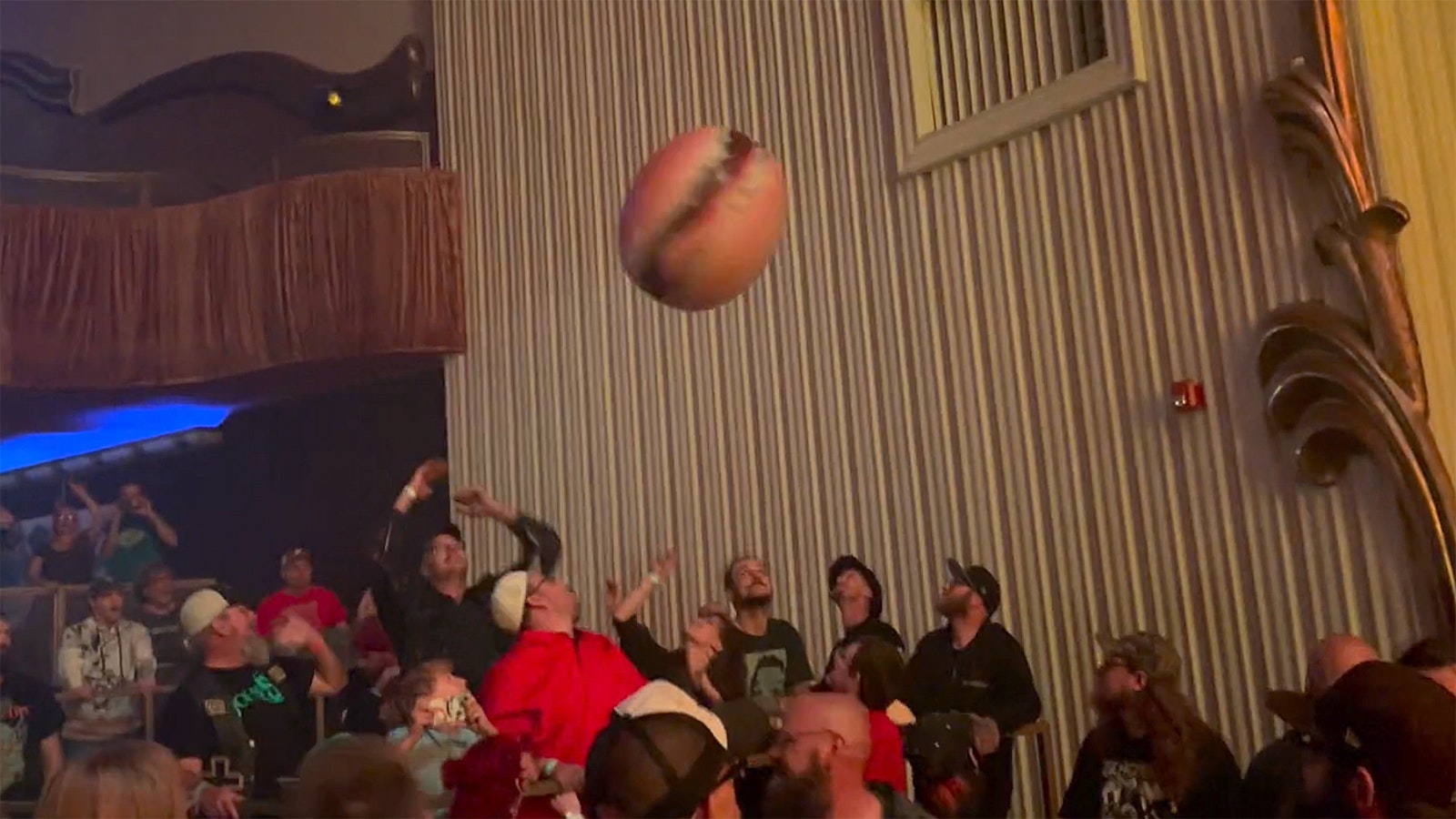 The crowd has fun with a giant inflatable hamburger.