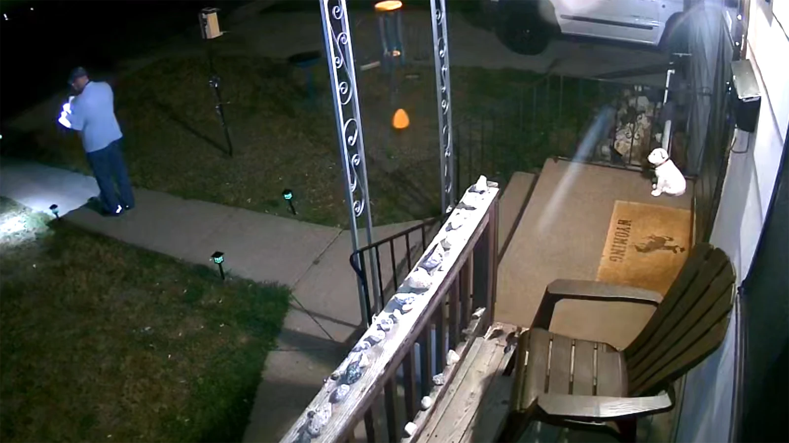 An outdoor camera shows a postal carrier using a flashlight after 1:30 a.m. to deliver mail in a Cheyenne neighborhood.