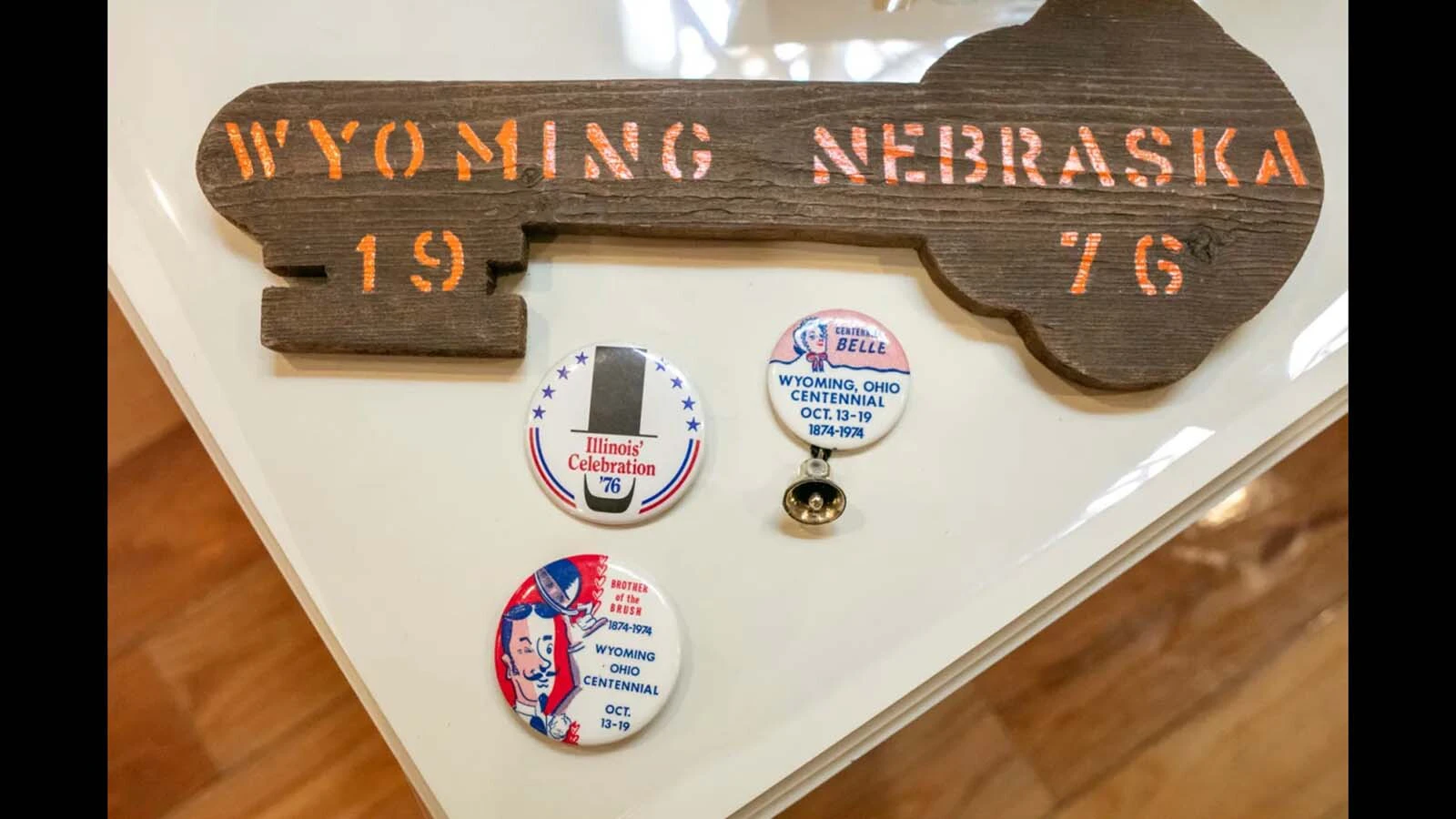 A collection of memorabilia from The Wyoming Trip including a key to the community of Wyoming, Nebraska, and souvenir buttons from Illinois and Ohio.