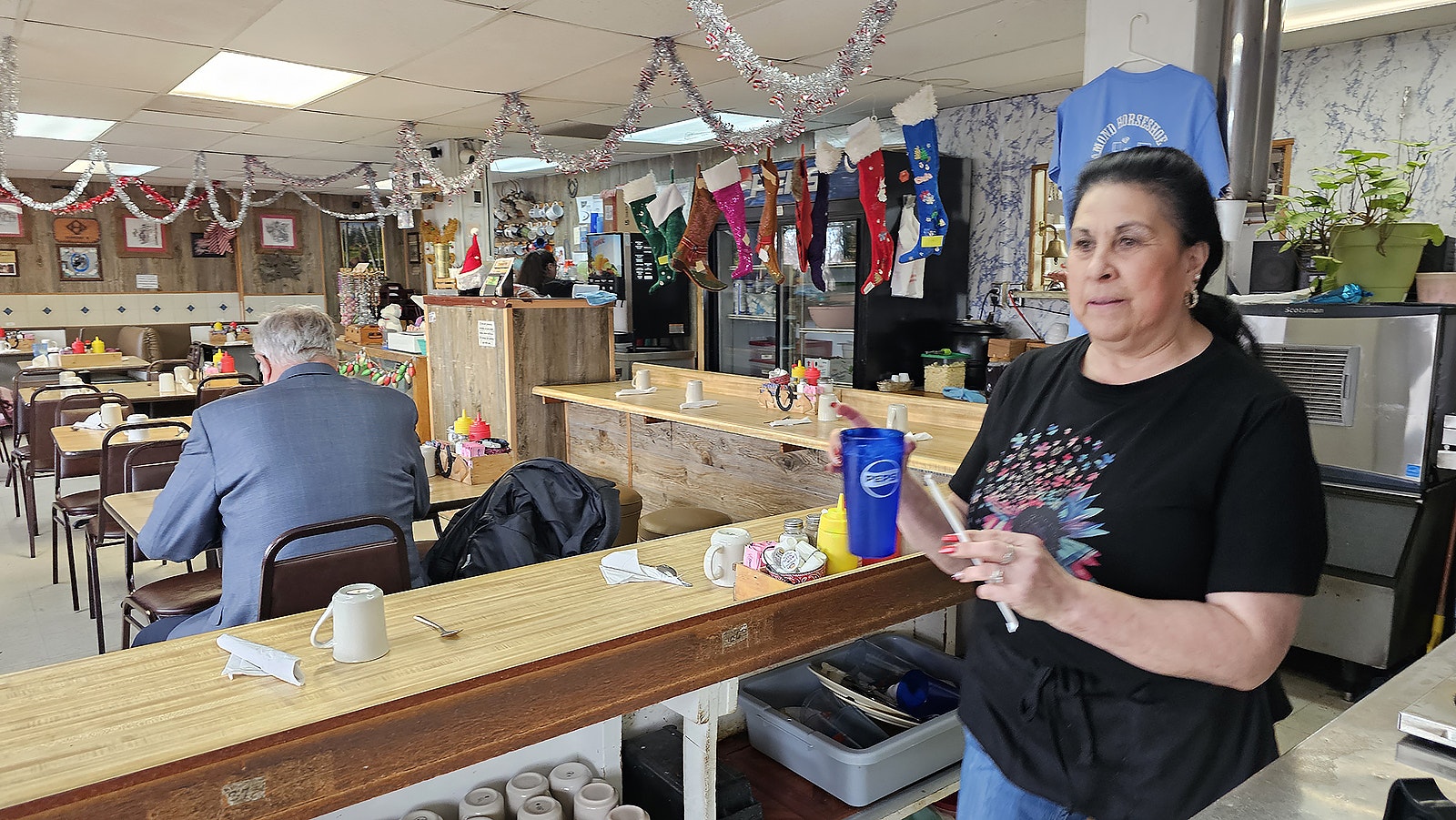 Margaret Lovato brings a glass of water to a new table of customers at Diamond Horseshoe Cafe in Cheyenne, where she has worked for almost 50 years.