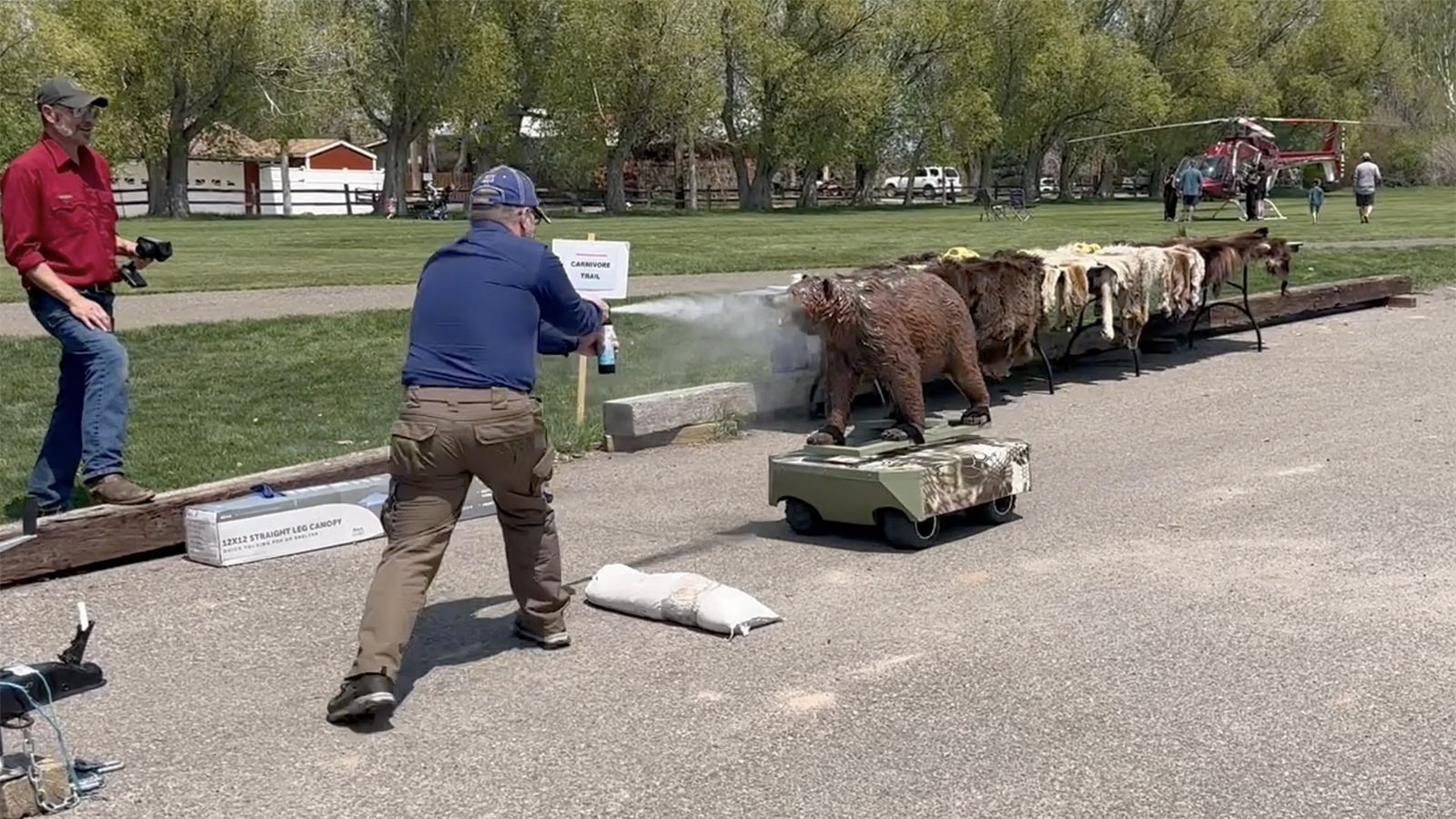 Cowboy State Daily outdoors reporter Mark Heinz gives "Robo-Bear" a snootful of bear spray during a demonstration in Lander over the weekend.