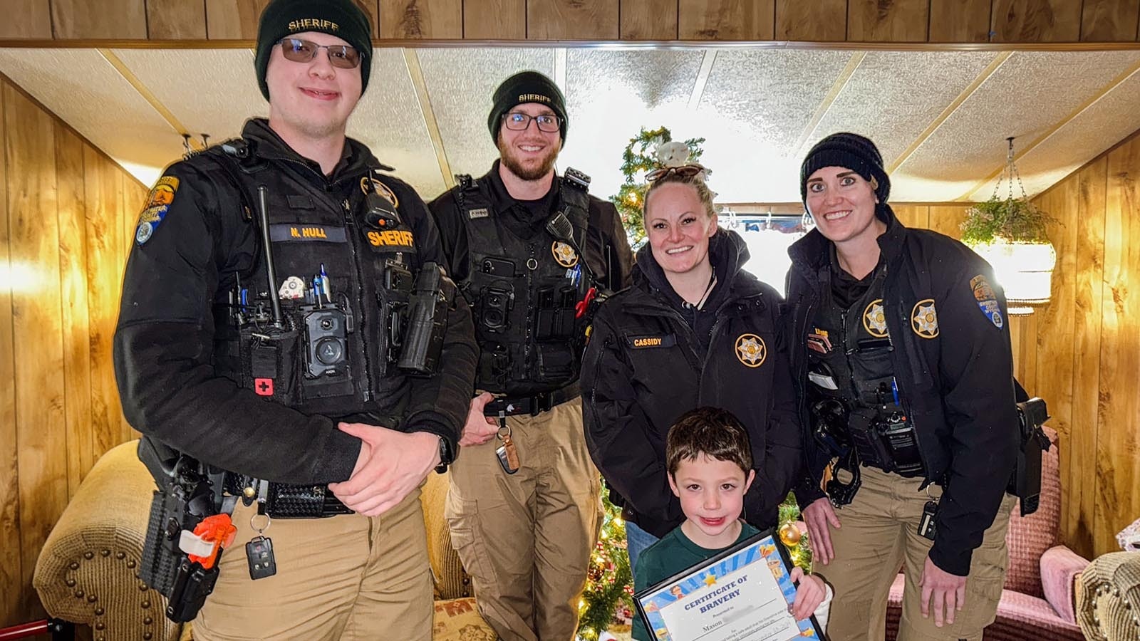 Deputies Nathaniel Hull and Zachary Otte, Detective Stephanie Cassidy, Deputy Ana Lindig and Mason Rasmussen, receiving a sheriff's award for bravery at his grandmother's home.