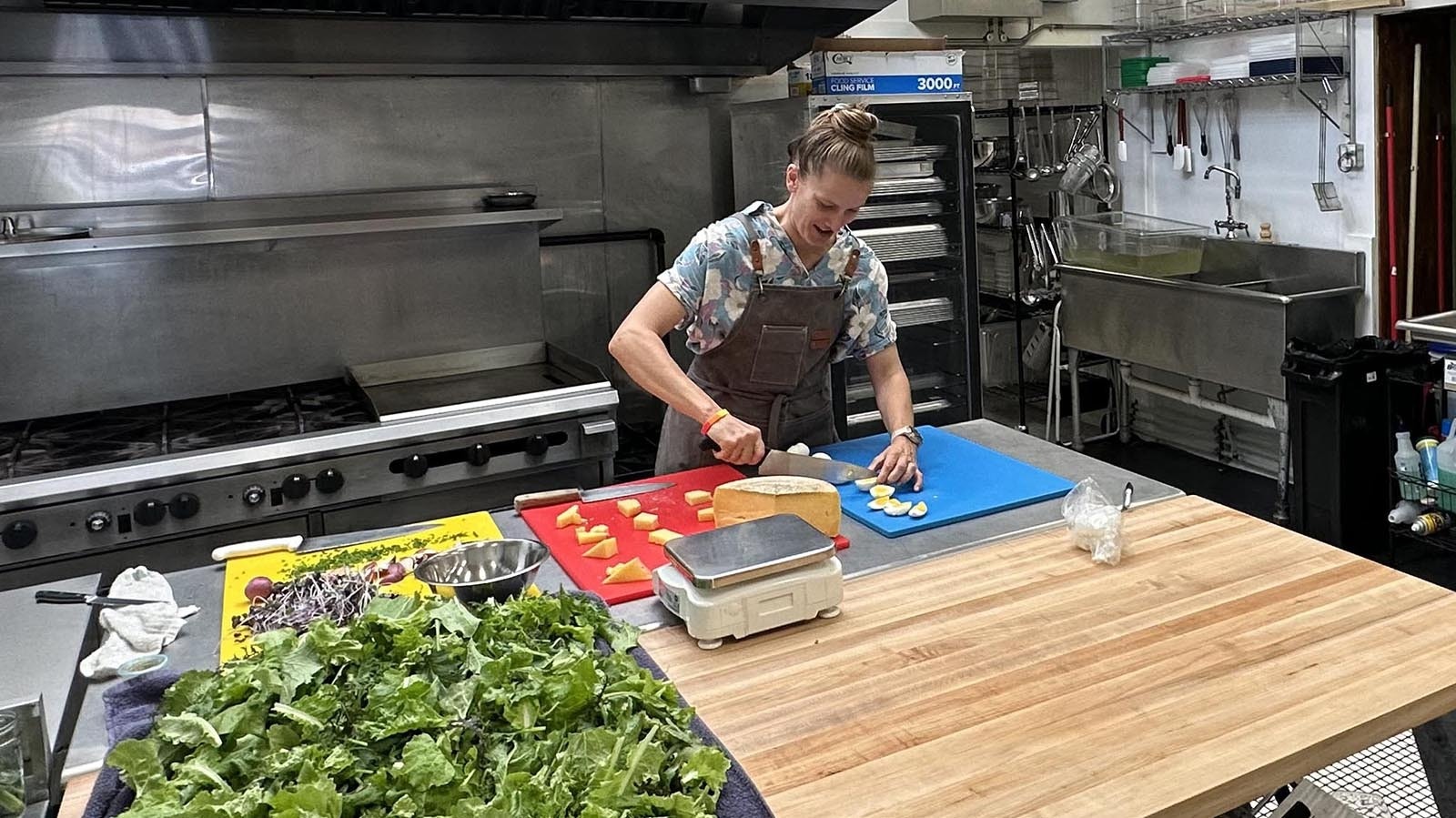 Hannah Darrin works in the industrial kitchen at Meadowlark Market and Kitchen preparing salads.