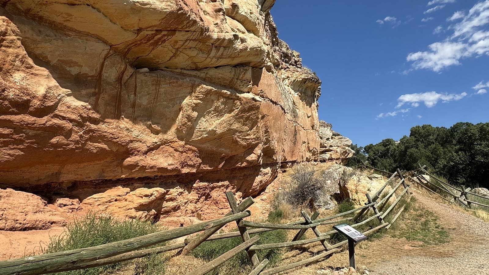 Interpretive sign along the sandstone bluff where the petroglyphs reside at Medicine Lodge Archaeological Site.