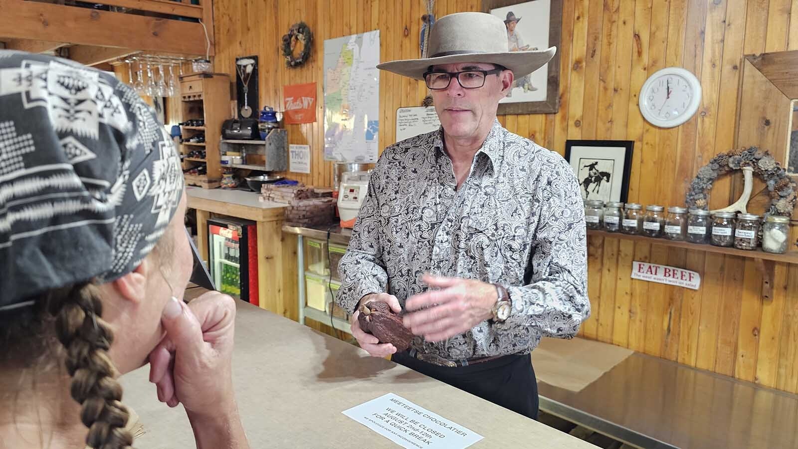 Tim Kellog, Wyoming's cowboy chocolatier, shows a  cacao pod to a customer in his shop, Meeteetse Chocolatier, in Meeteetse, Wyoming.