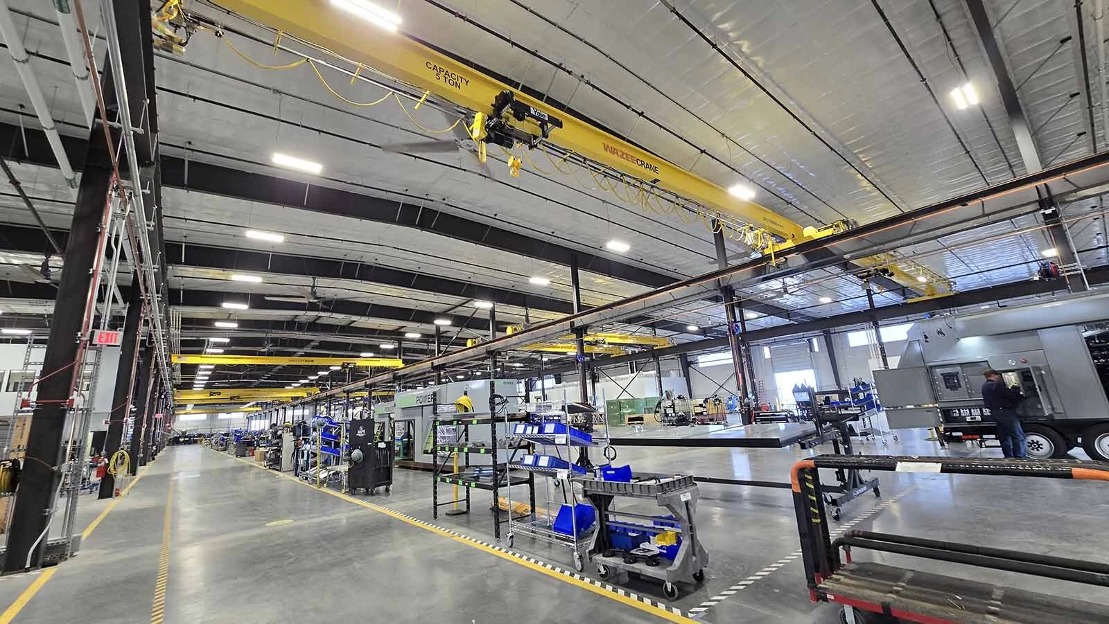 The overhead yellow beams are a crane system that allows large pieces to be "flown" over a power generator in progress.