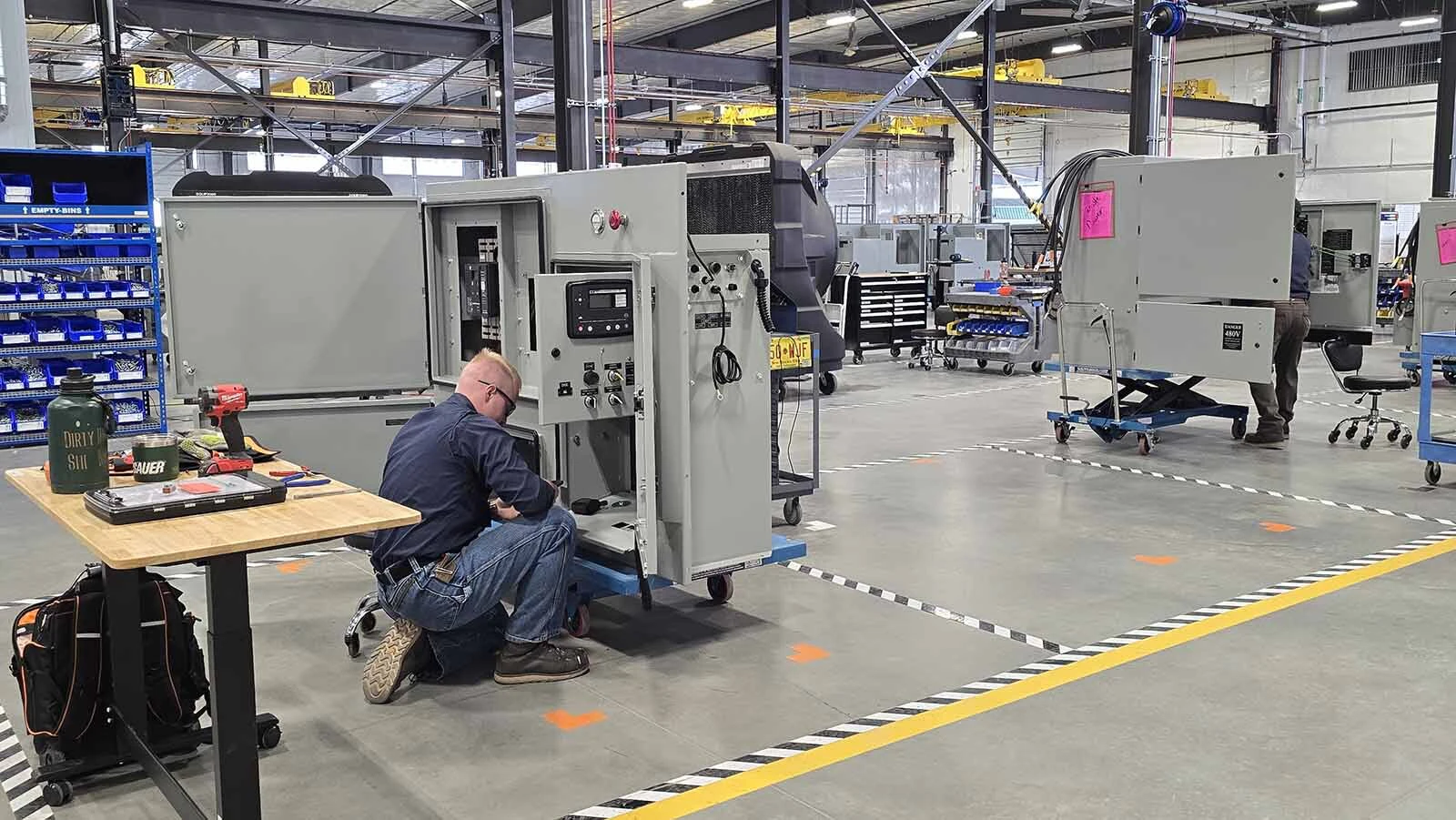 A Mesa Power Solutions employee works on a component for a standby power generator.