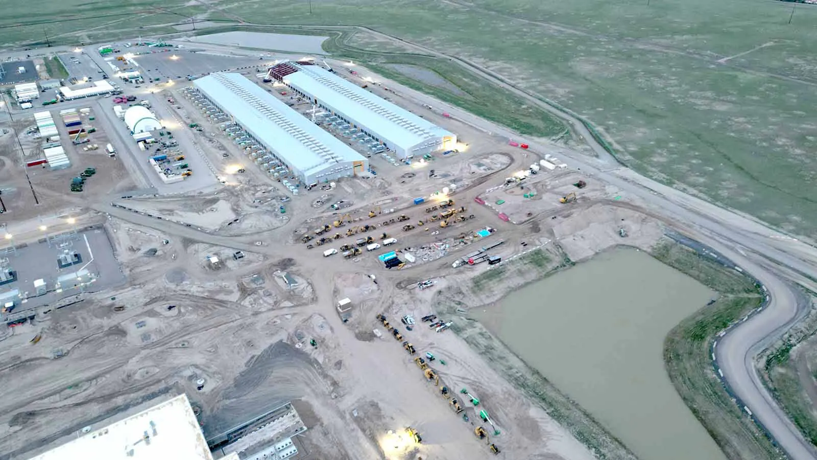 An aerial view of the Meta data center being built in south Cheyenne. A water retention pond is shown near the edge of the development.