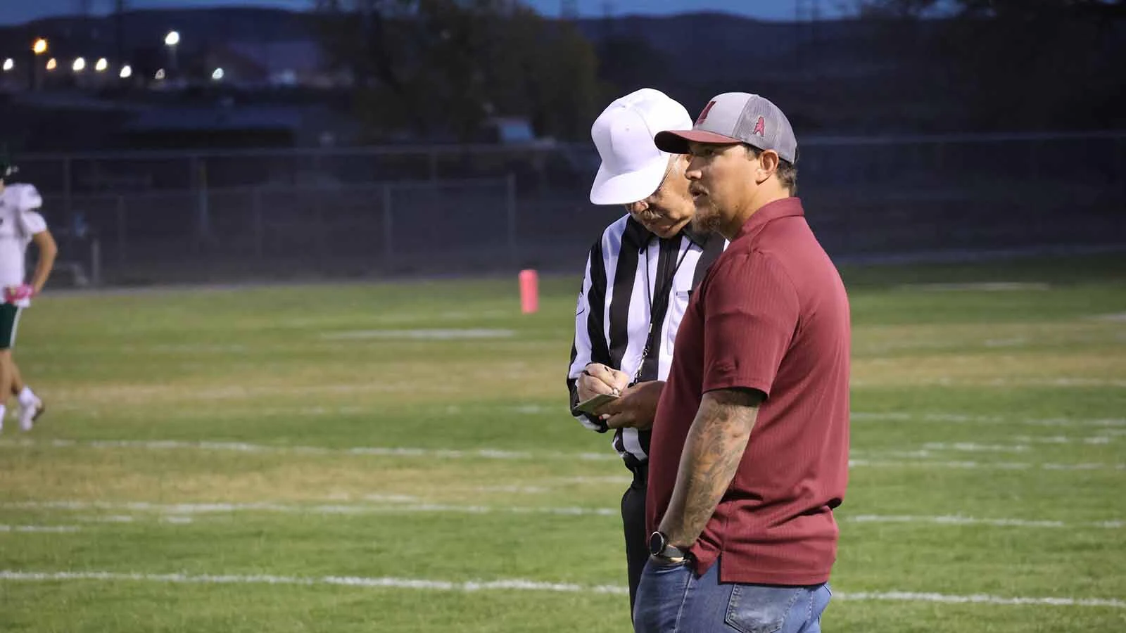 Josh Lindsay, the Midwest Oilers coach, speaks with an official before the football game. 