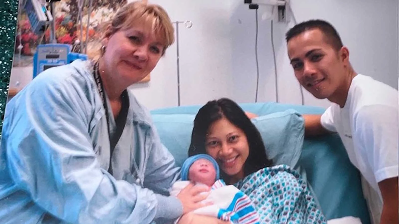 Helen LaRose poses with a newborn baby and its happy family just after the baby was born.