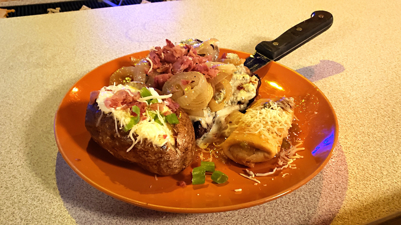 The Bobbie Blue Bland served with a baked potato and signature miniature chimichanga on the side.