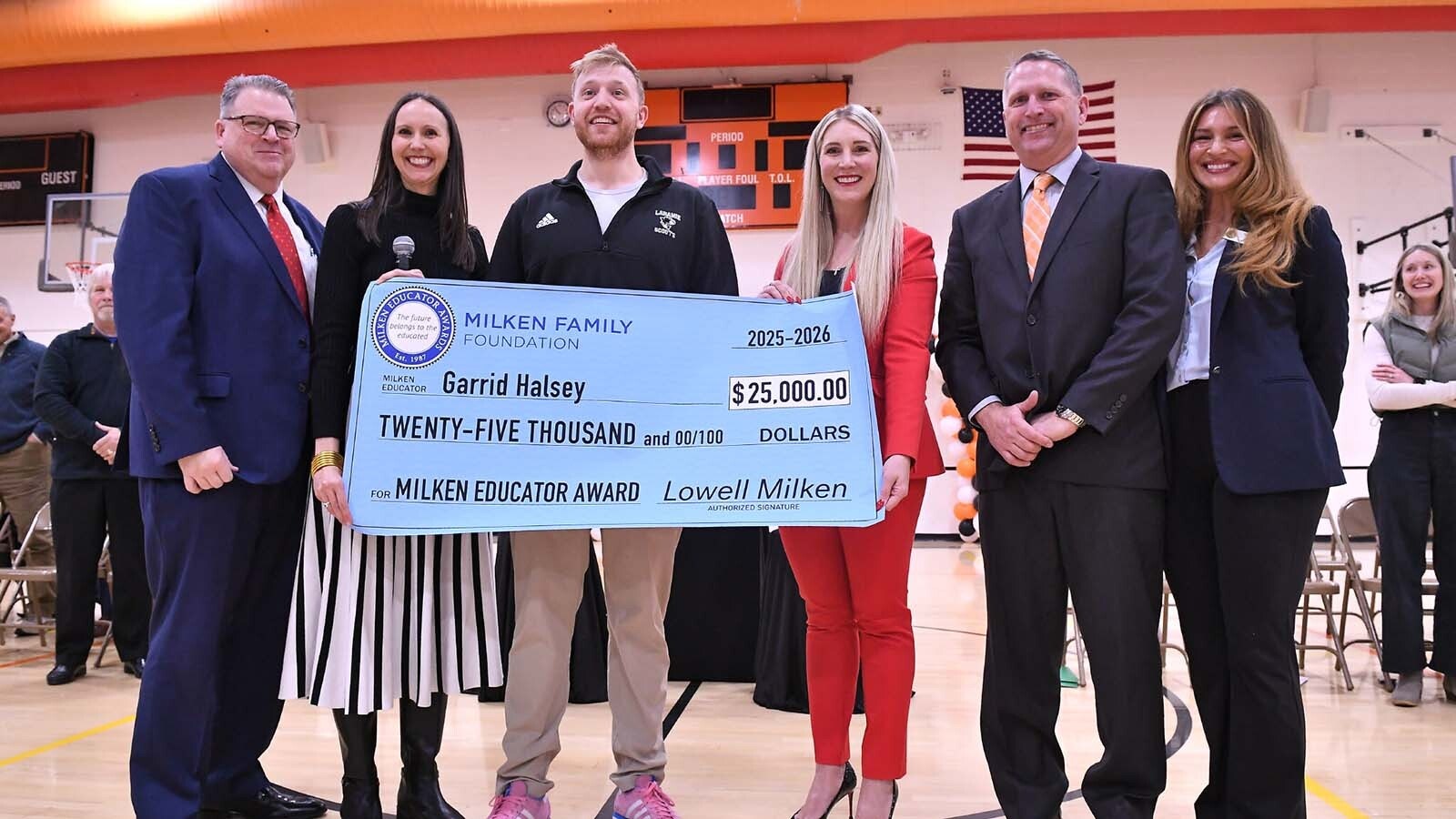 Garrid Halsey gets a hand with his oversized check. Pictured from left, Albany School District 1 Superintendent Dr. John Goldhardt; Milken Educator Awards Vice President Jennifer Fuller; Halsey; Wyoming Superintendent of Public Instruction Megan Degenfelder; Laramie Middle School Principal Kevin O'Dea; and Wyoming Department of Education Teacher Leadership & Awards Consultant Madison Lacey.