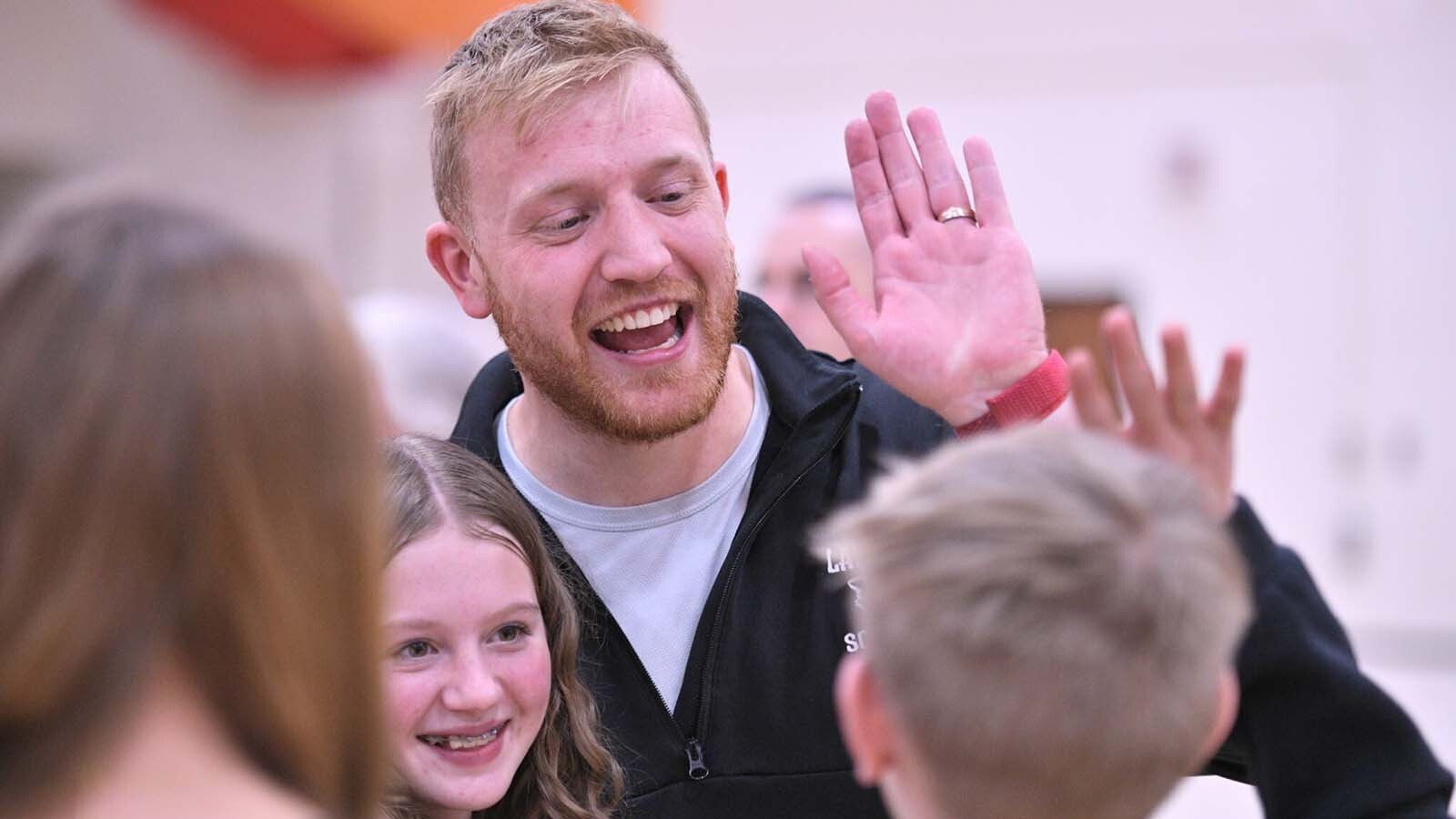 Garrid Halsey is congratulated with high-fives from students.