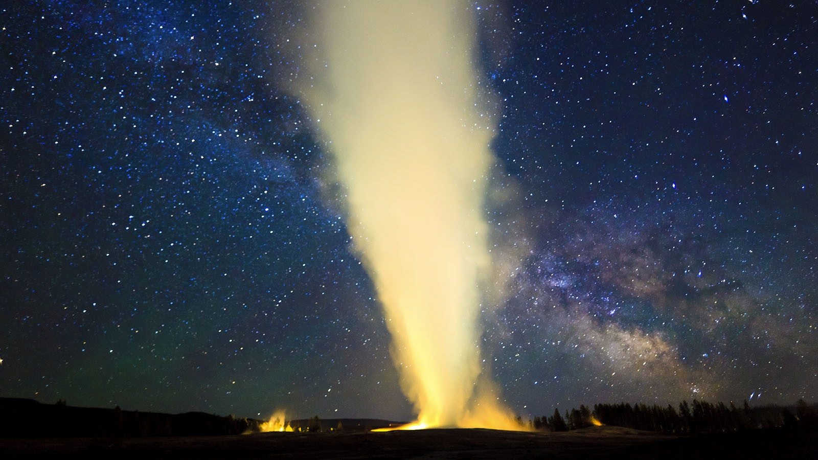 The Milky Way Galaxy as seen in the pristine night skies over Wyoming. Old Faithful blows under a clear sky and a view of the Milky Way.