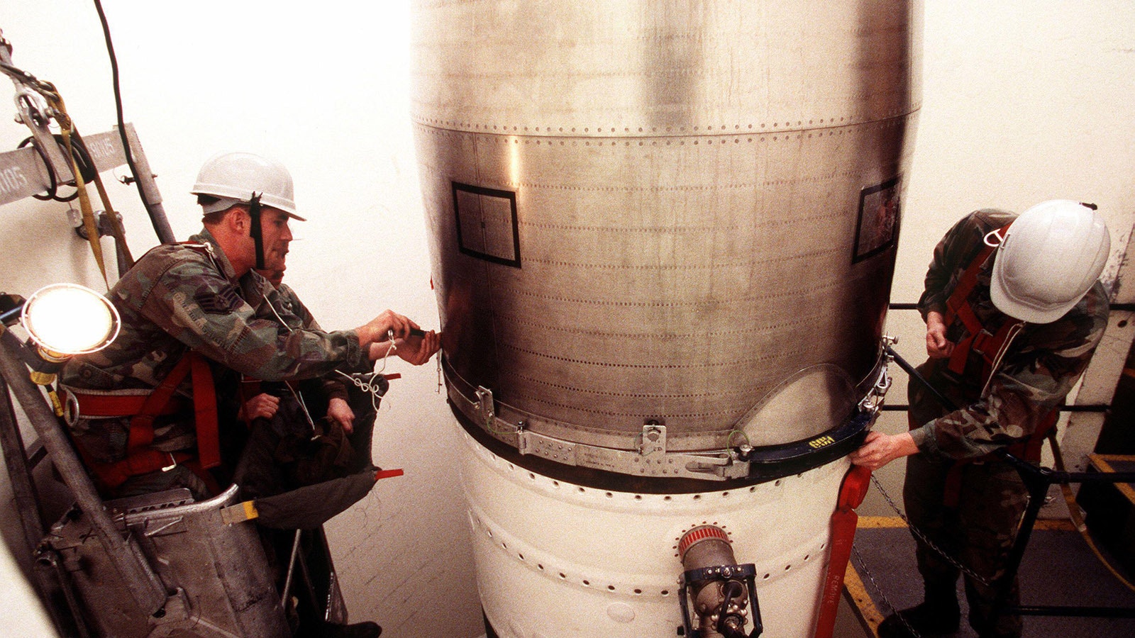 At Minuteman Missile Silo Alpha-7 technicians Staff Sgts. Jason Bruns, from left, Monte Reeder and Senior Airman Eric LaBorne tighten the bolts on the upper stage of a Minuteman III missile at F.E. Warren Air Force Base in Wyoming.