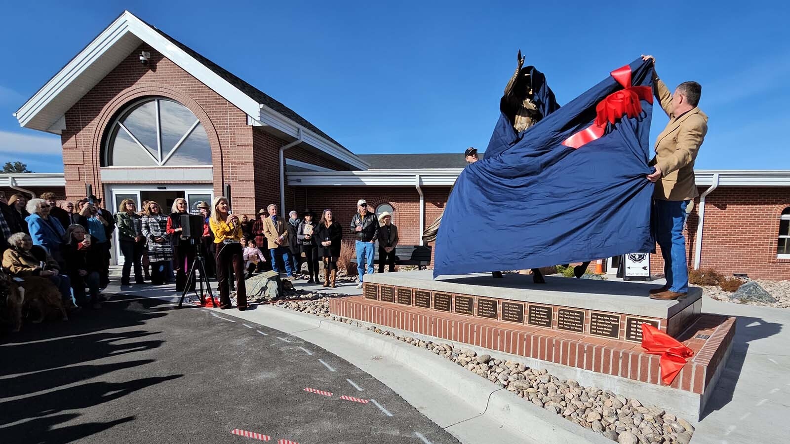 Harvey Deselms works to unveil Miss Frontier during a ceremony at Frontier Park in front of the Old West Museum.