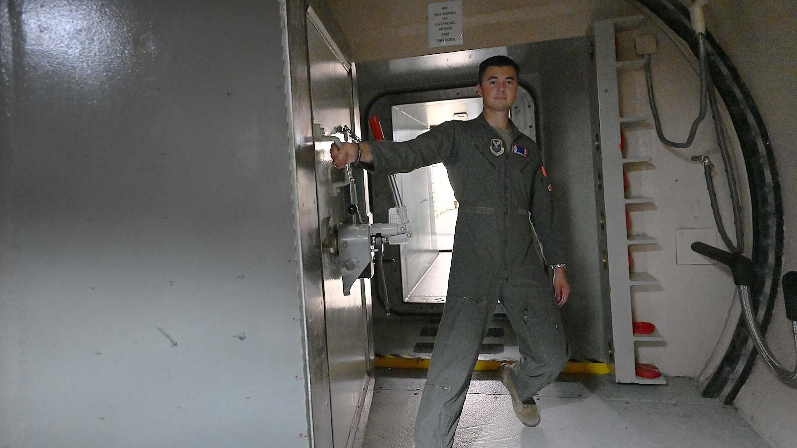 An airman opens a blast door.