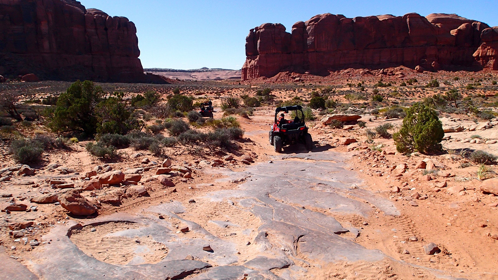A line of ATVs make their way across a rugged trail through the Moab region of Utah.