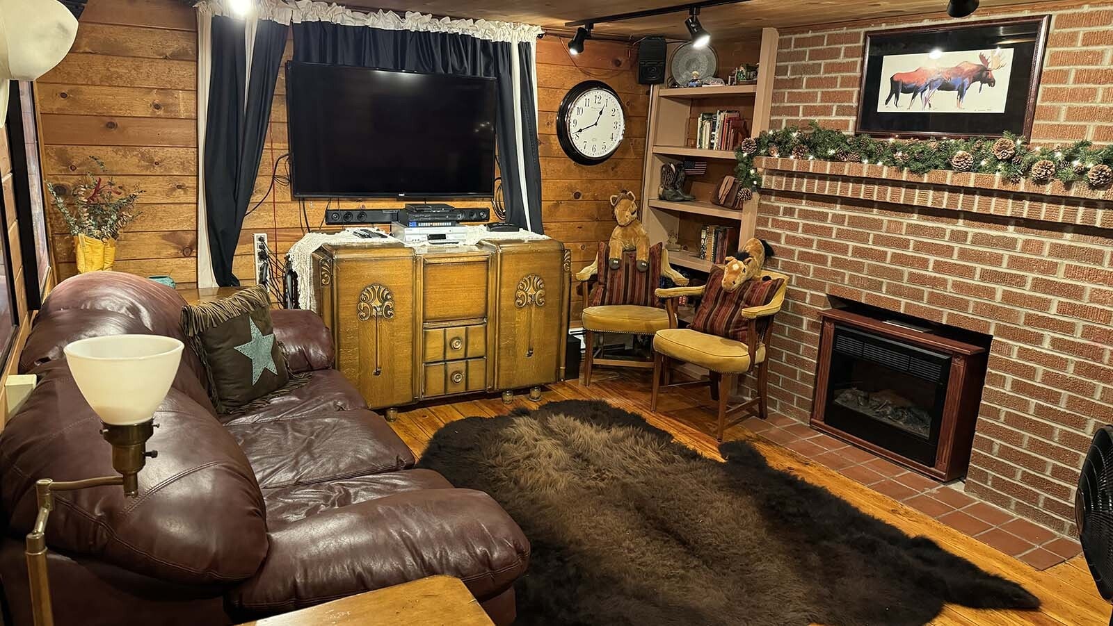 A leather couch and period sideboard cabinet.