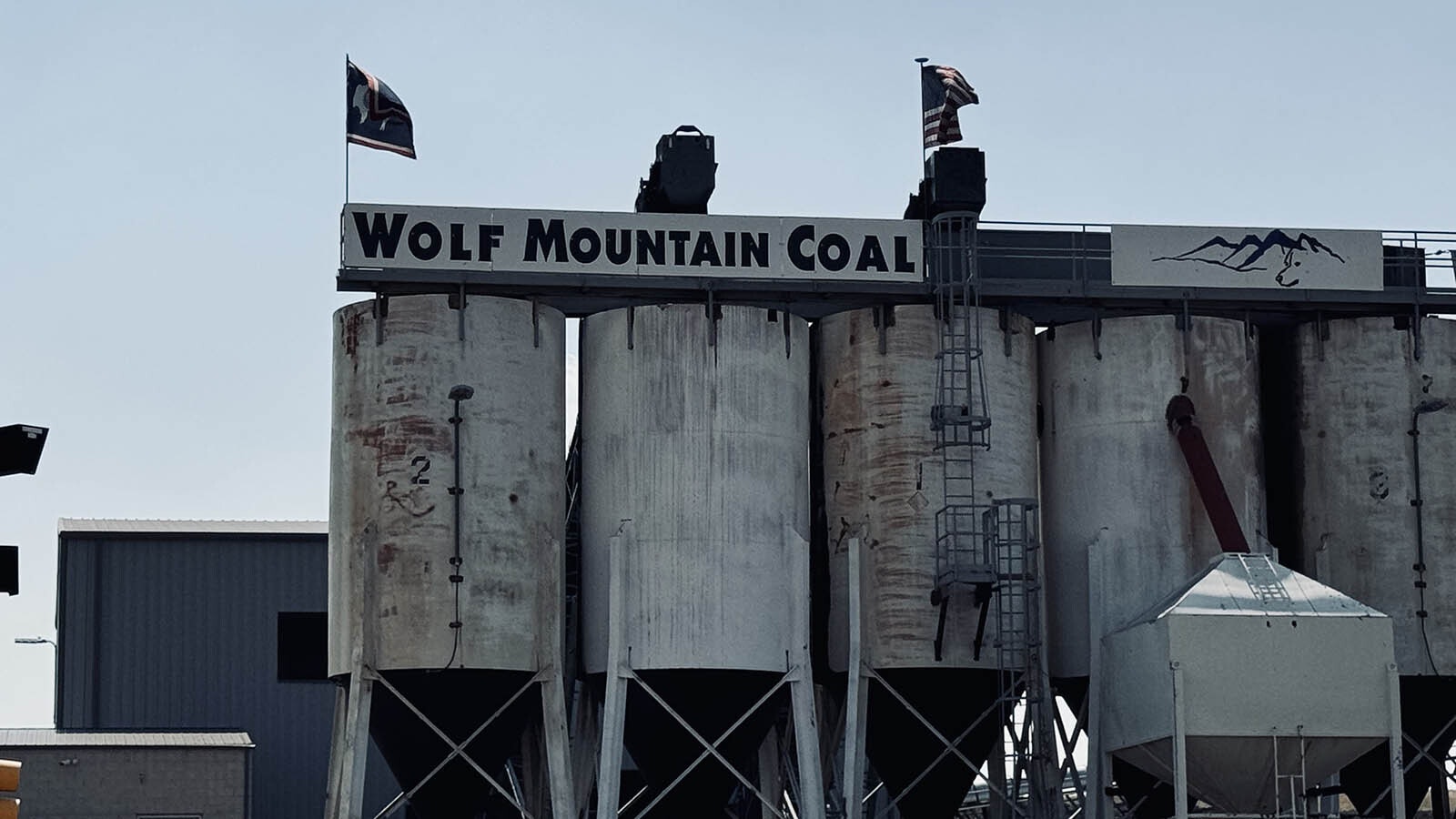 On the left, a Wyoming bison flag flies above one of Wolf Mountain Coal’s storage silos along the main road between Sheridan, Wyoming, and Decker, Montana.