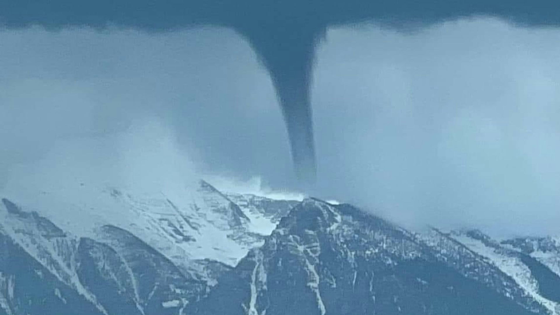 This photo of a land spout over a mountain peak in Montana went viral on social media.