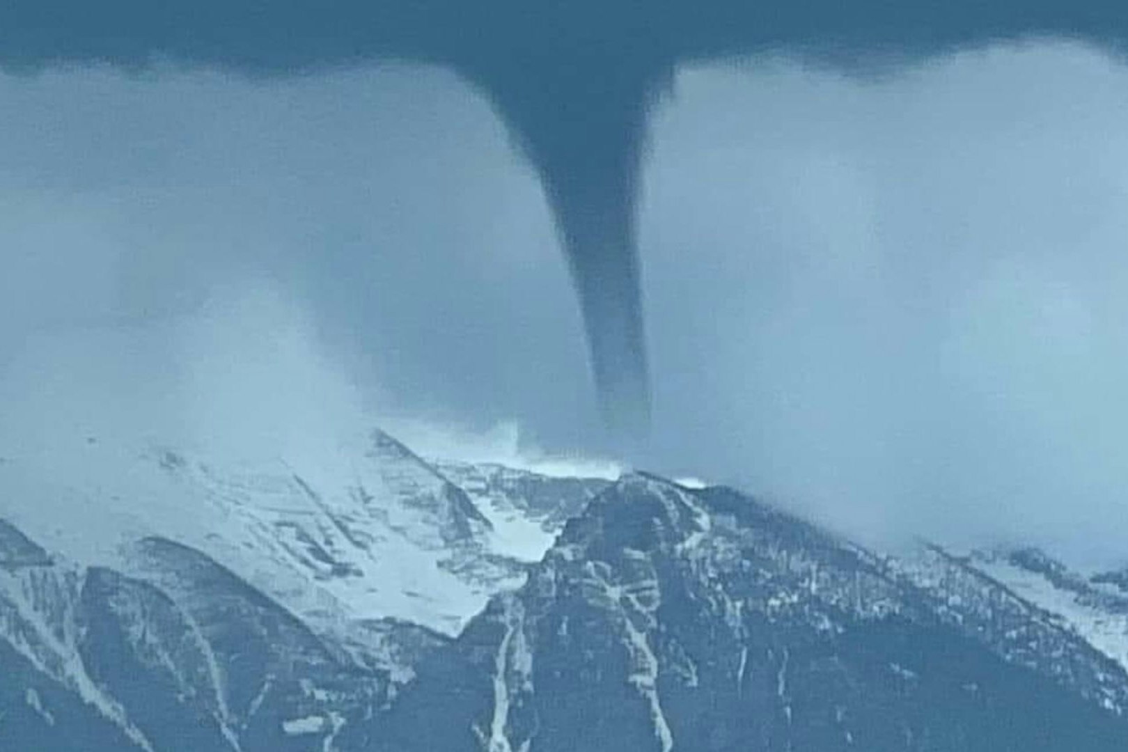 This photo of a land spout over a mountain peak in Montana went viral on social media.