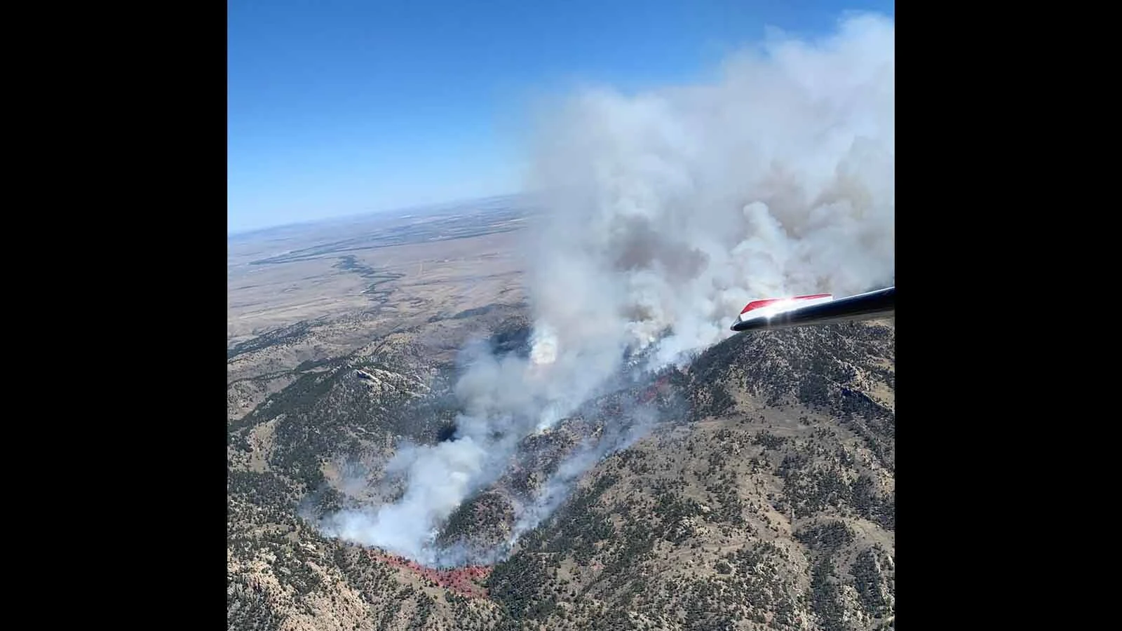 An aerial view shows smoke pouring from the Moonshine Fire in the Laramie Range, where difficult-to-access terrain has complicated firefighting efforts.