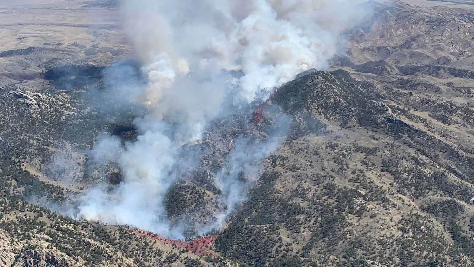 An aerial view shows smoke pouring from the Moonshine Fire in the Laramie Range, where difficult-to-access terrain has complicated firefighting efforts.