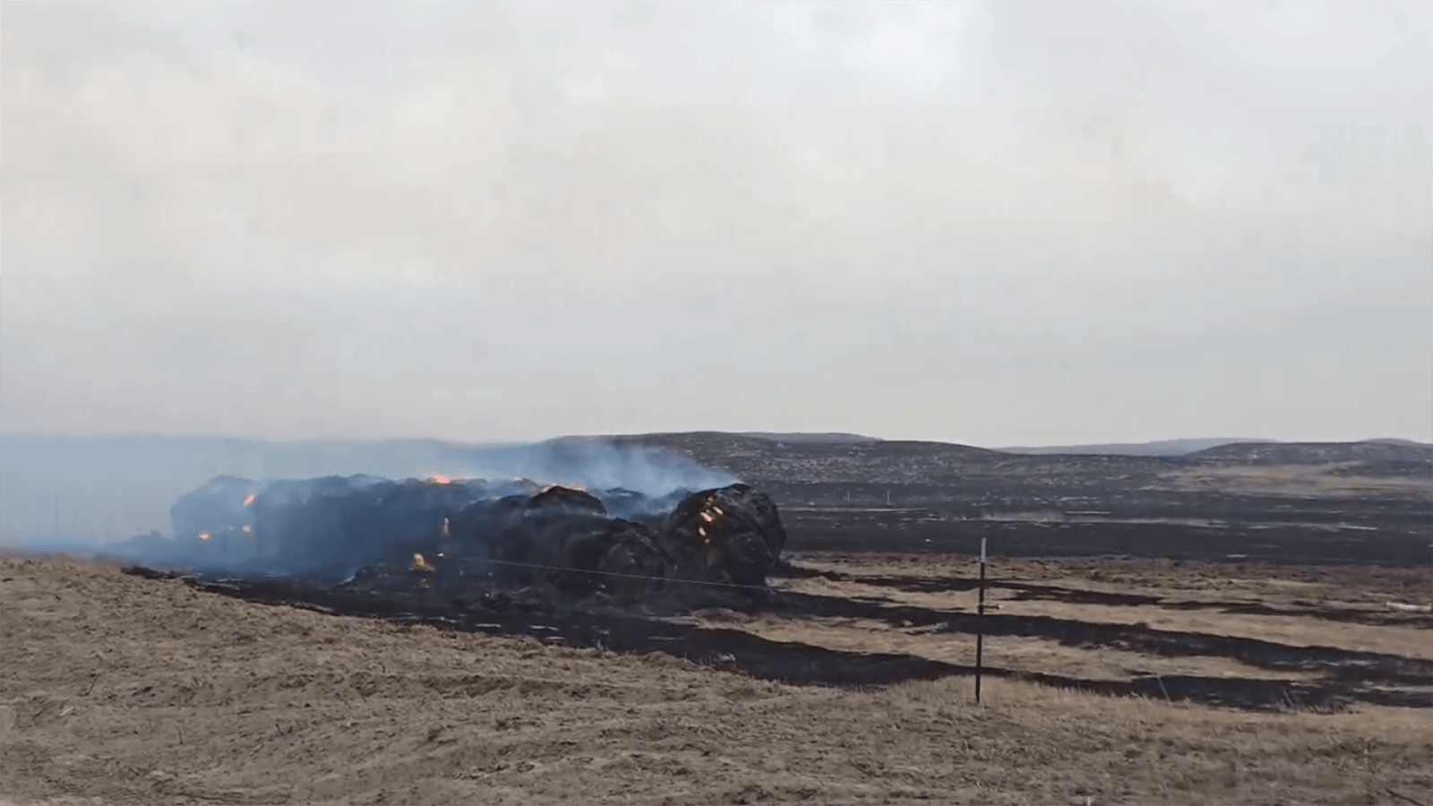A stack of hay bales burns in the path of the Morrill Fire in Nebraska.