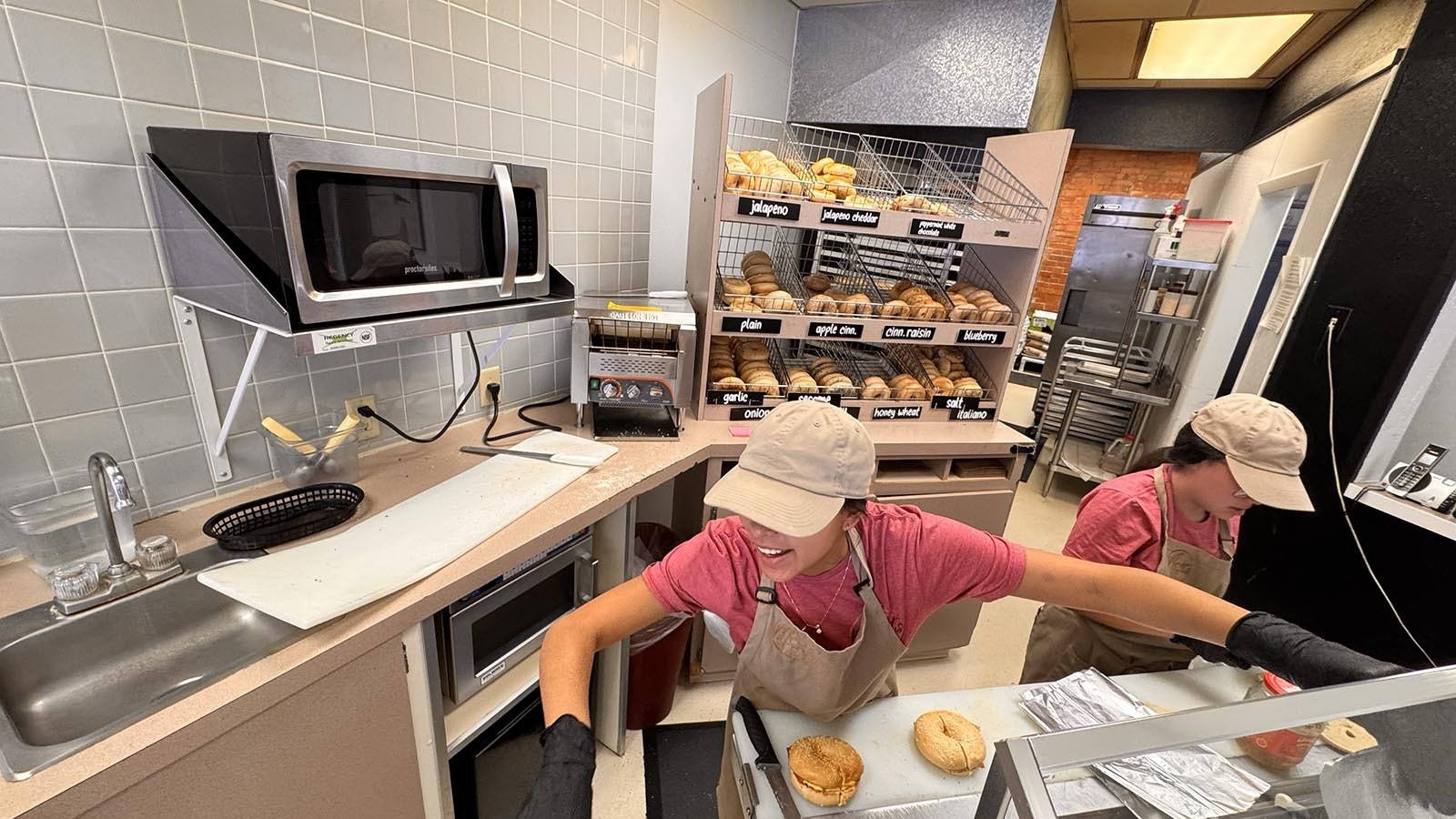 Danica Chavez, left, and her sister Jessica work fast behind the counter at Mort's Bagels. Even when it's 20 degrees and snowy outside, the business at the downtown Cheyenne, Wyoming, bagel shop is brisk on a Sunday morning, Jan. 5, 2025.