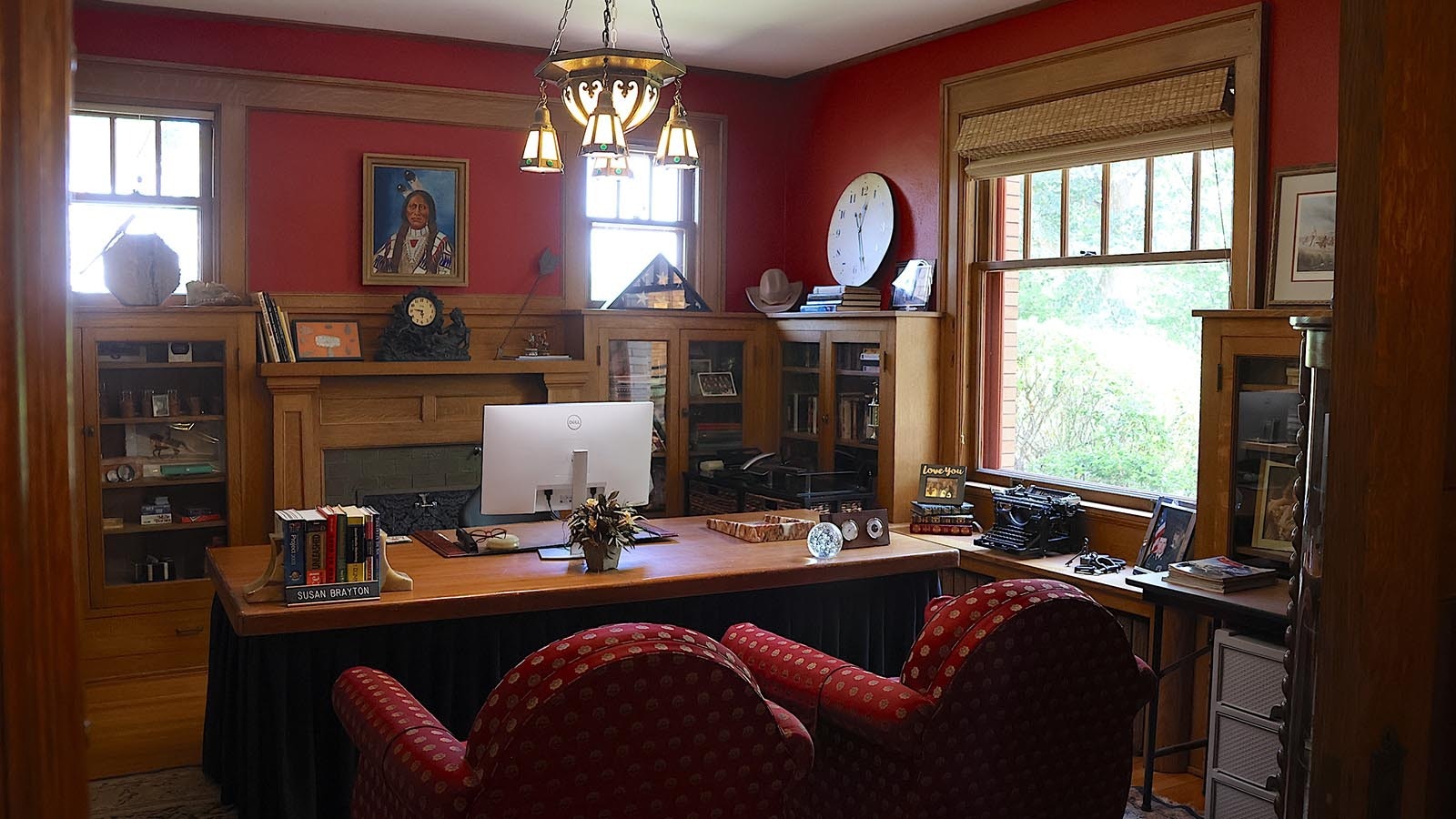 The office and den on the main floor offers built-in wooden bookcases and shelves – and its own working fireplace.