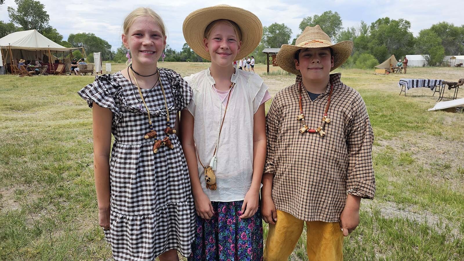 From left, Cecilia and Charlotte Livingston and William Hawton model some polar bear knucklebone necklaces at the 1838 Riverton Rendezvous going on now through July 6.