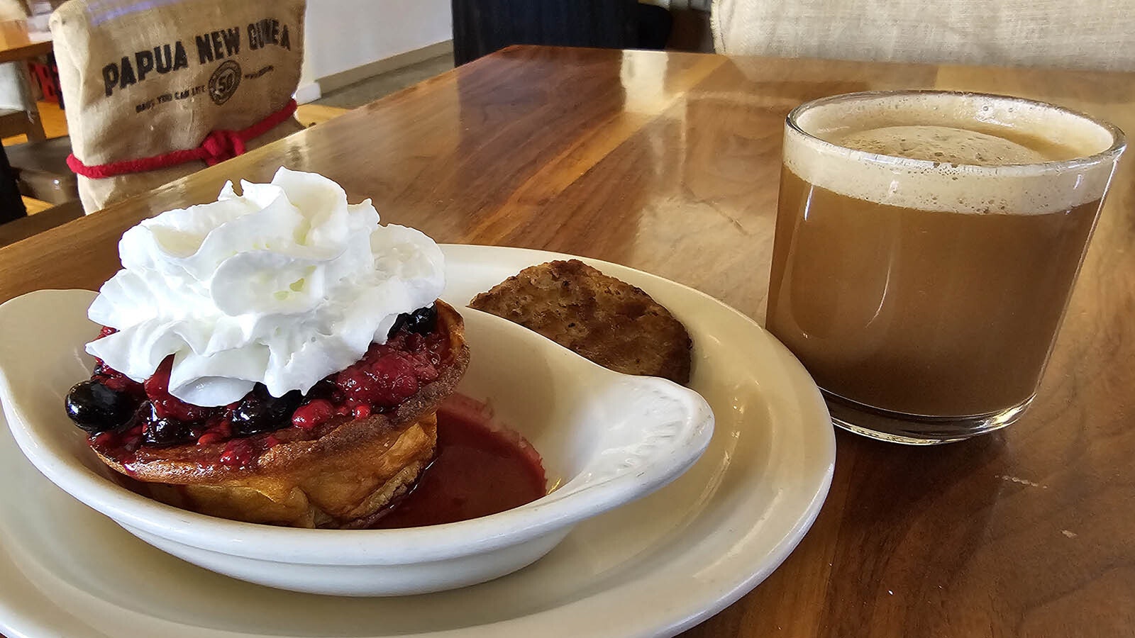 The Dutch baby is topped with a berry compote and whipped cream. It goes well with a side of sausage and a latte.