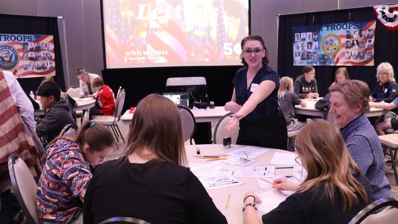 Letters of Hope station. Rockpile Museum volunteers Brittney Elsasser and Shelly Clark, seated right, assist sixth graders in writing letters from Campbell County’s war veterans.