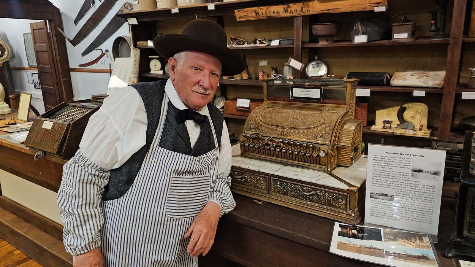 Jim Robinson poses near a cash register in the Hoofprints of the Past Museum in Kaycee, with a hat he shaped for the cattle drive era. Robinson is a member of Platte Bridge Company and was helping  put on a Living History Day in Kaycee during Chris LeDoux Days final event.