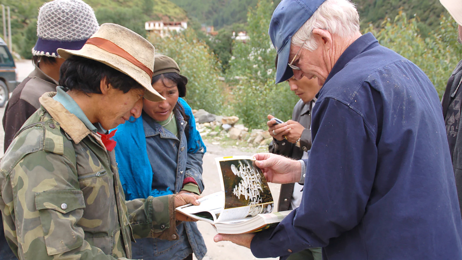 Mushroom marketers from Tibet and Japan being helped with mushroom identificaiton by Dr. Jack States.