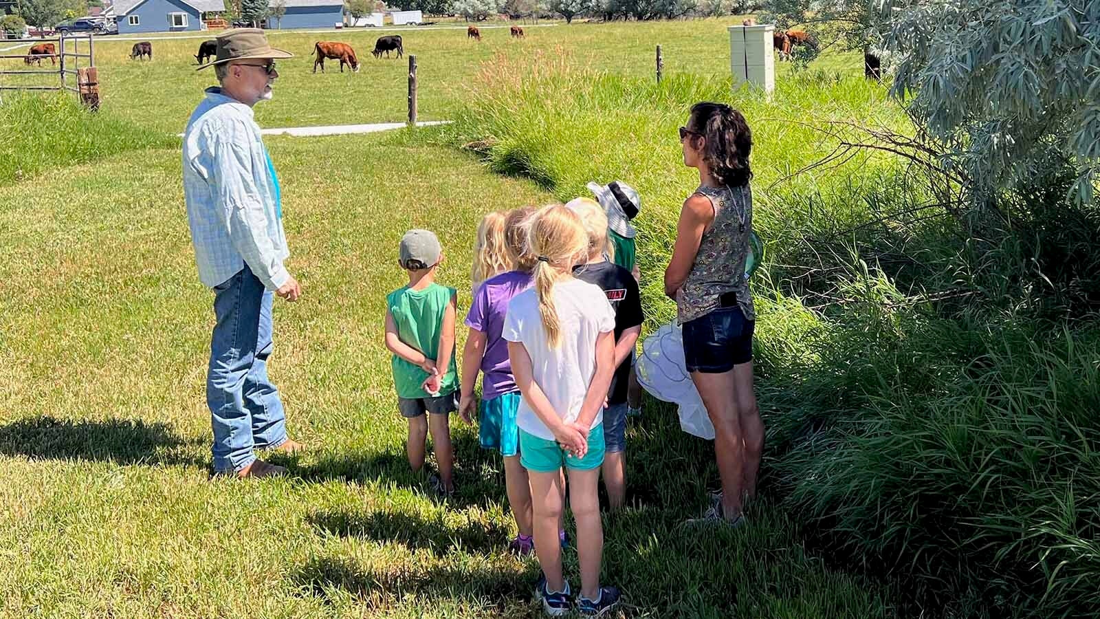 Alan Frost talks to students at the Academy of the Winds in Lander about the Frost's beehive located on school property.