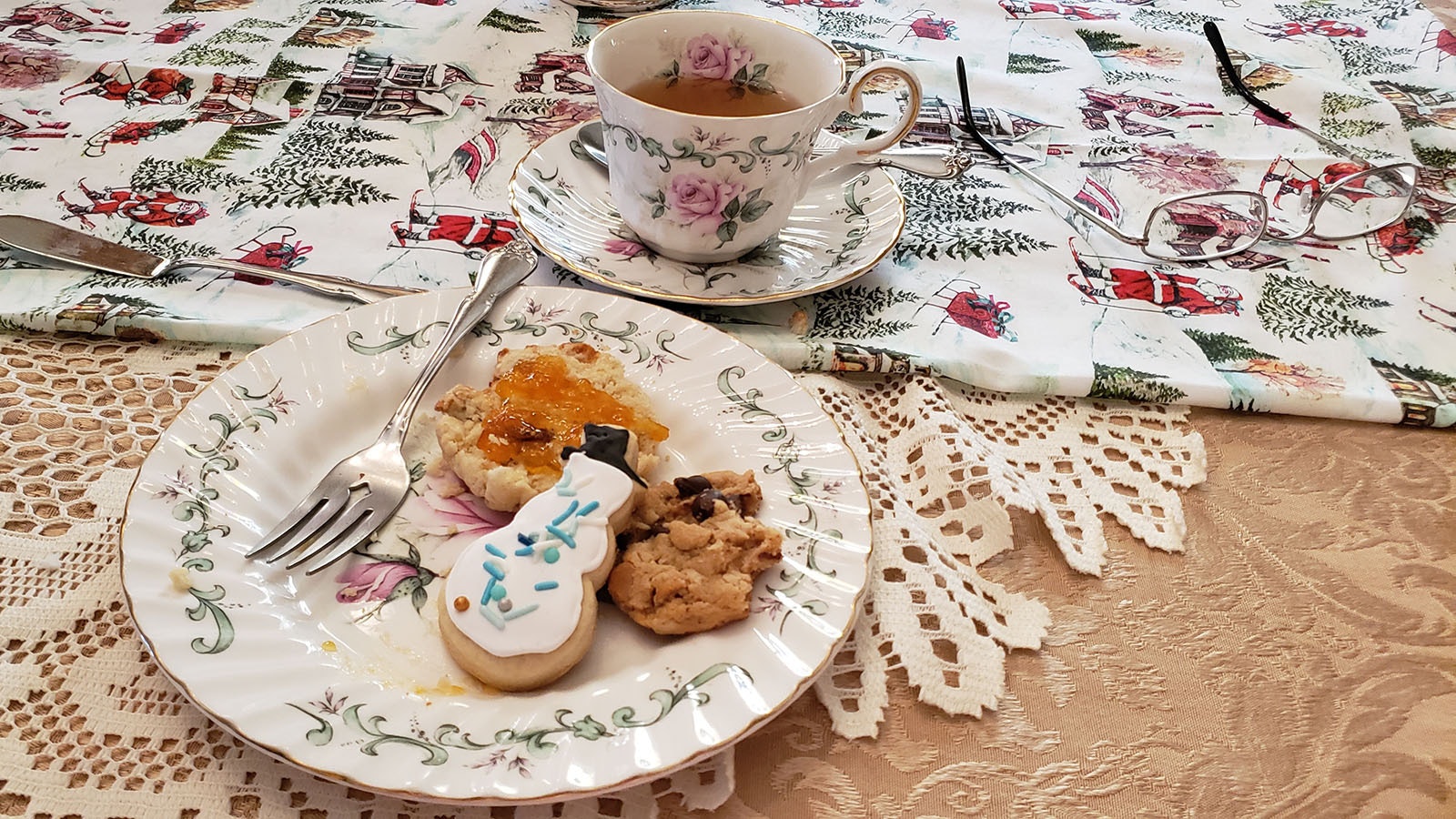 Scones with apricot jelly, a snowman sugar cookie and a cowboy cookie with peppermint tea.