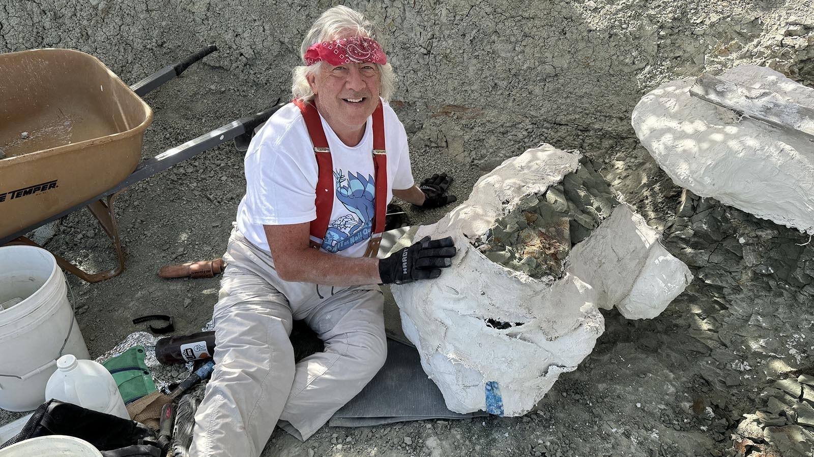 Jim McKeeman with the Western Interior Paleontological Society sits next to a recently flipped jacket containing several dinosaur bones. A "clean" jacket is one where there isn't any dinosaur bones sticking out of the bottom, but there's no way to know that until its flipped.