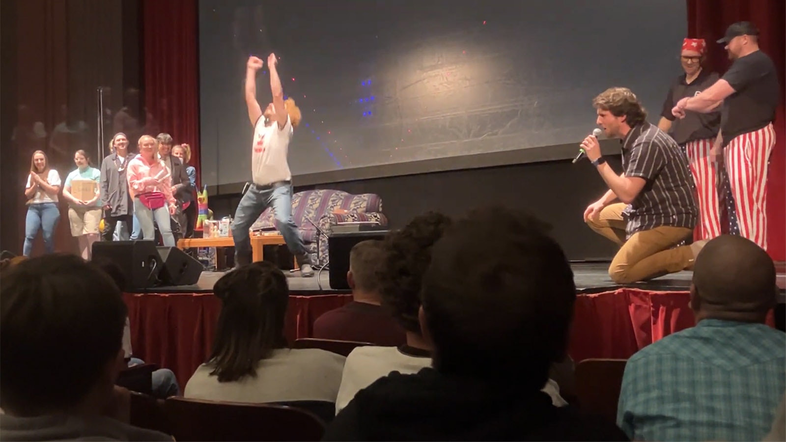 A screenshot of an attendee at Friday's "Napoleon Dynamite" event in Missoula, Montana, doing the iconic Napoleon dance, with actor Jon Heder commenting at right.